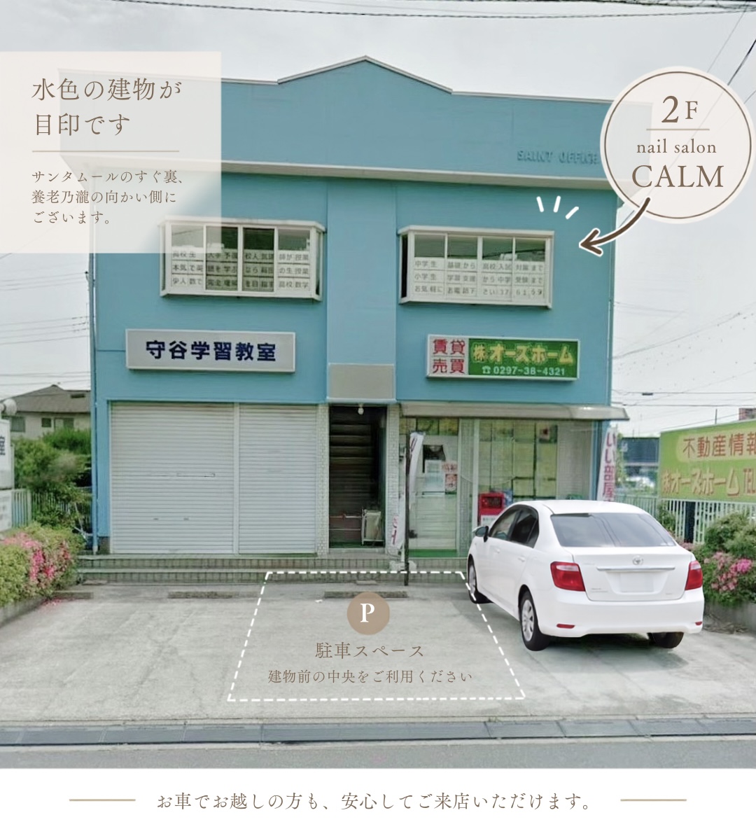 水色の建物2階にあるnail salon CALMと、建物前中央の駐車スペースの案内