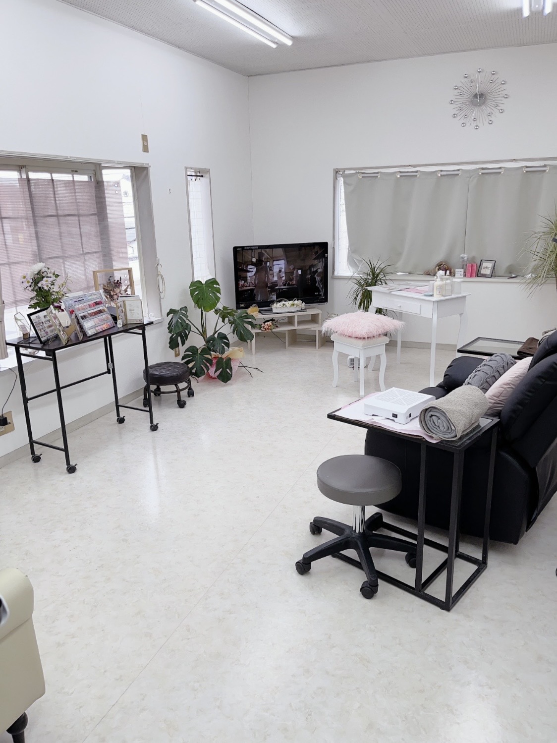 nail salon CALMの店内。窓、植物、施術スペースのある室内